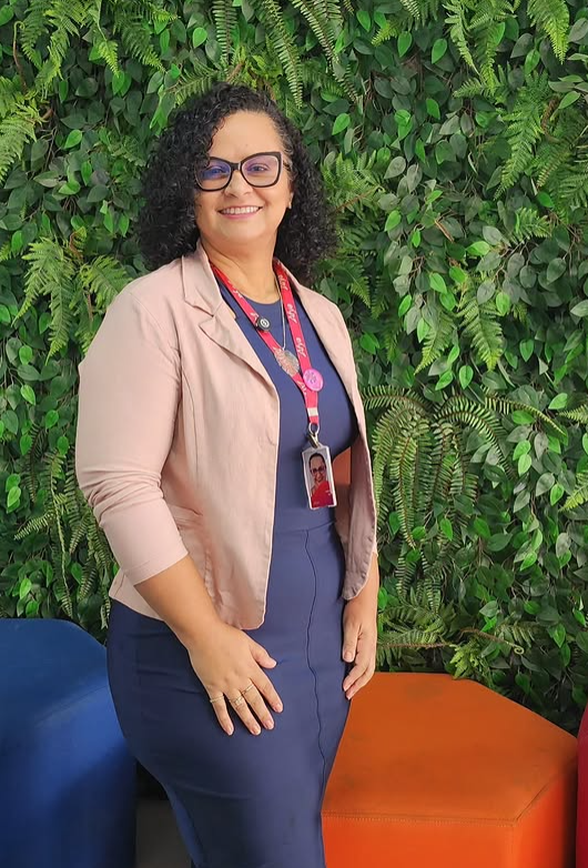 Denise Ana Oliveira diante de um jardim vertical